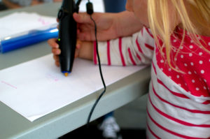 young girl with a 3D pen